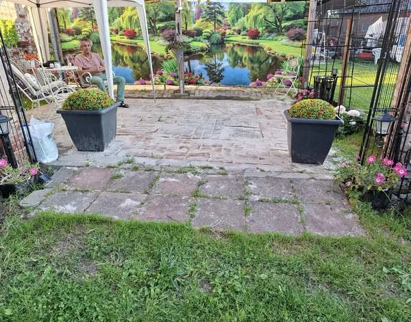 Gartenposter Gartenposter Ein üppig grüner Garten mit lebhaften Blumen und Bäumen rund um einen ruhigen Teich — Inspiration unserer Kunden